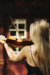 a woman in a black dress playing a violin