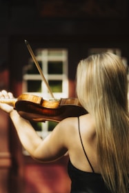 a woman in a black dress playing a violin