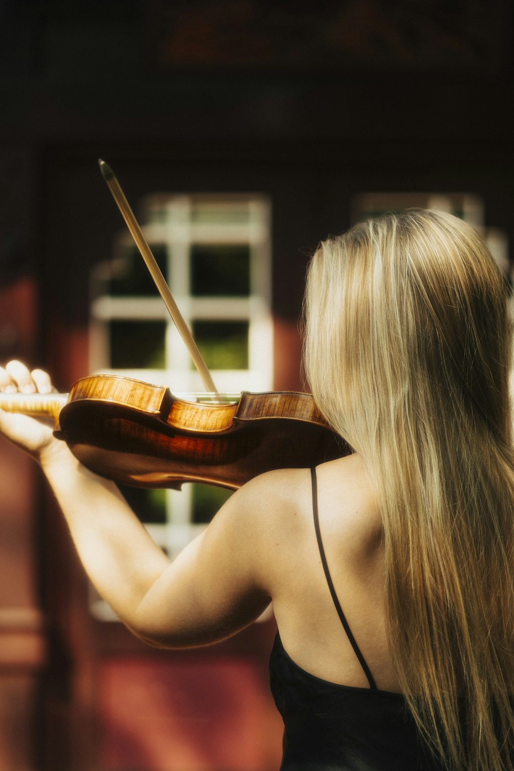 Una mujer con un vestido negro tocando un violín