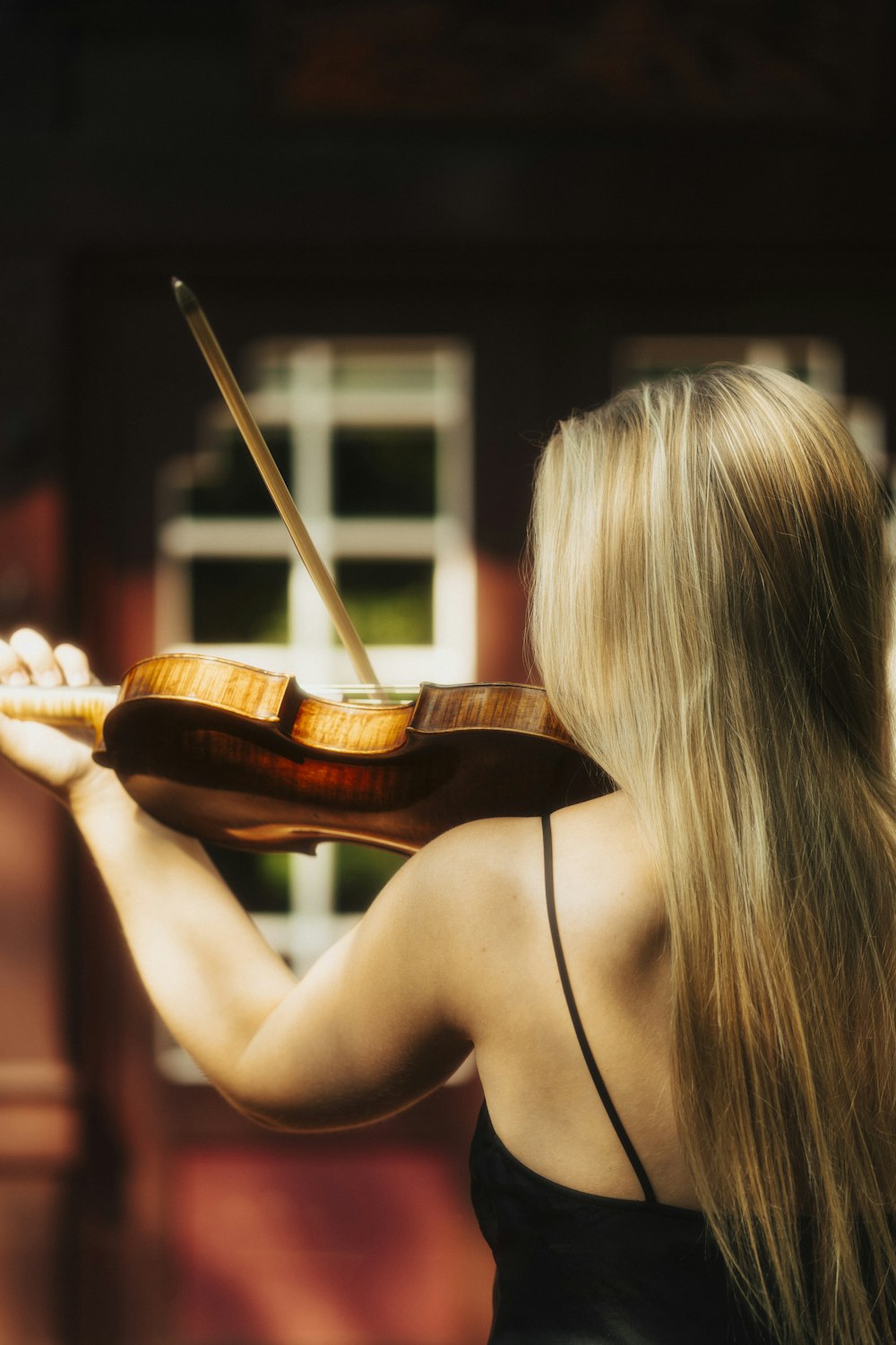 a woman in a black dress playing a violin