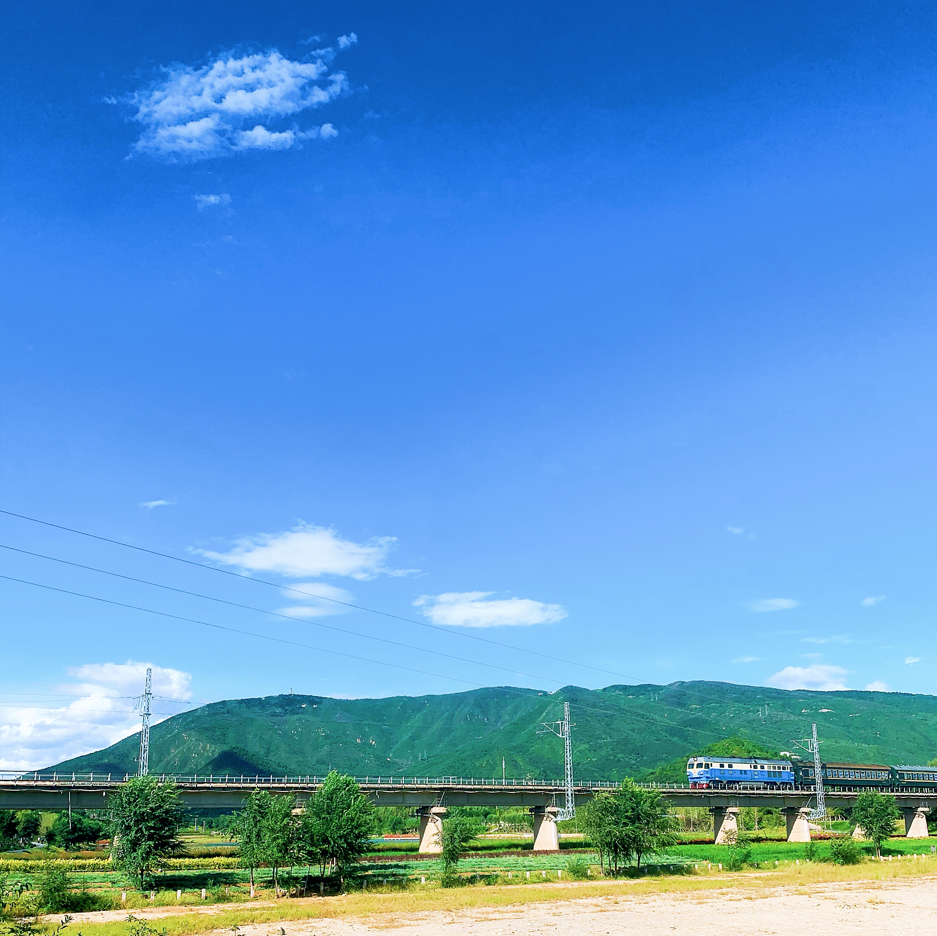 a train traveling over a bridge with mountains in the background