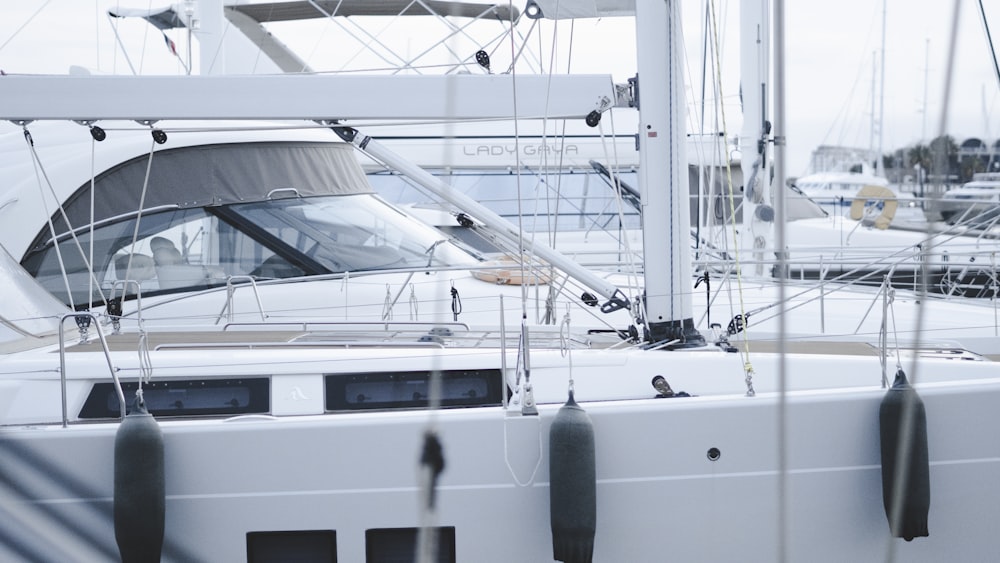 a white boat docked at a marina with other boats