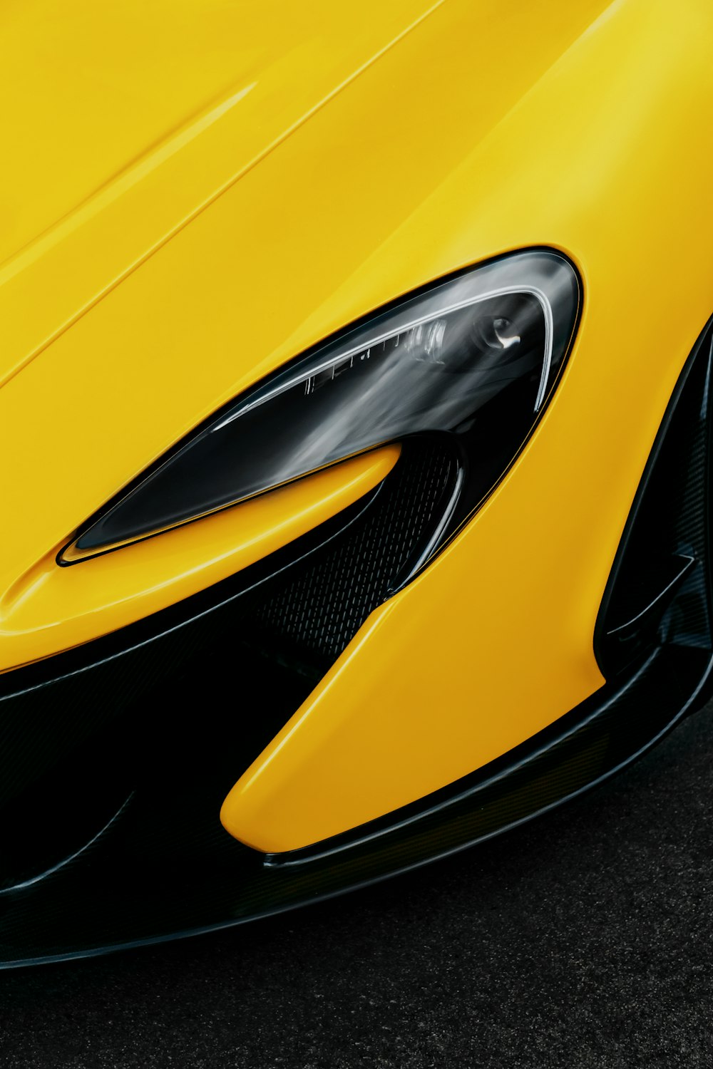 the front end of a yellow sports car