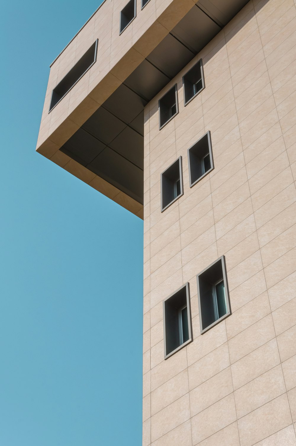 a tall building with windows and a sky background
