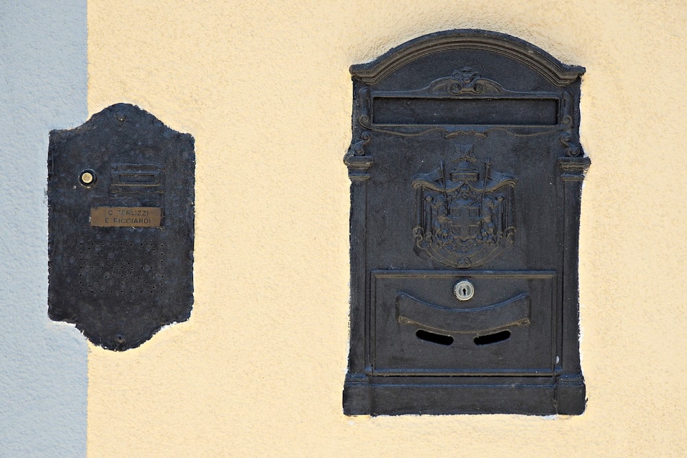 a black mailbox mounted to the side of a building