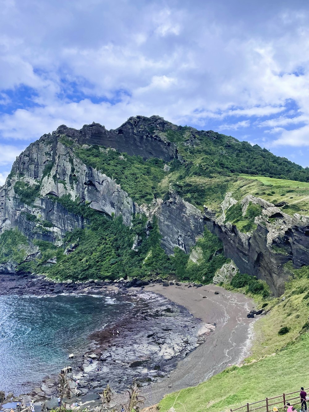 a grassy hill with a body of water below it