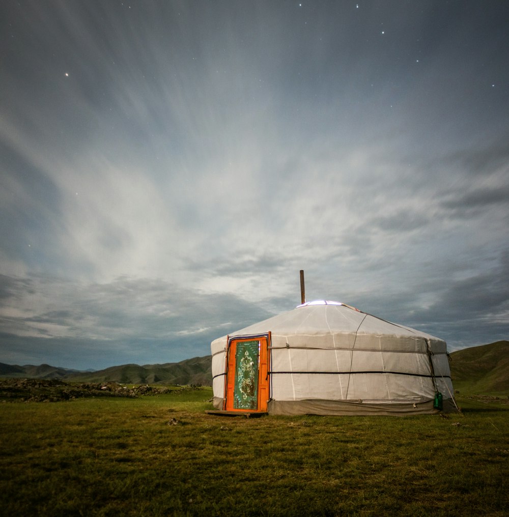 a yurt in the middle of a grassy field
