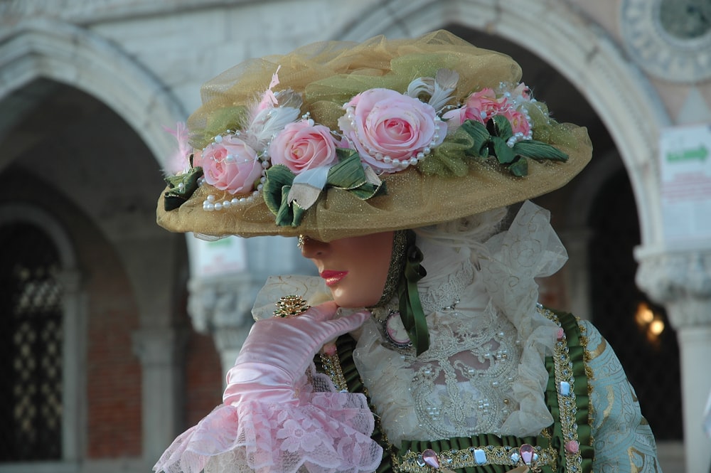 a close up of a person wearing a hat with flowers on it