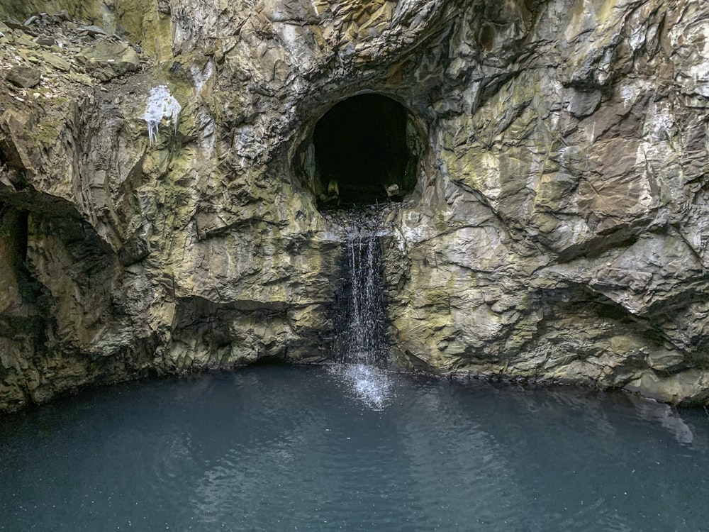 a cave with a waterfall coming out of it