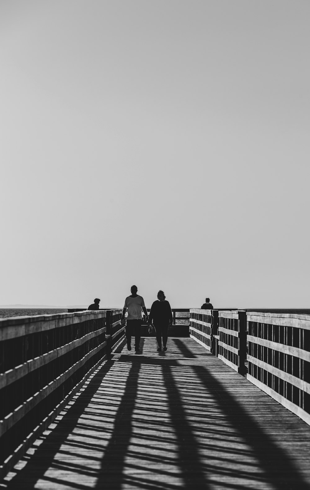 a couple of people walking across a bridge