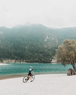 a person riding a bike on a beach
