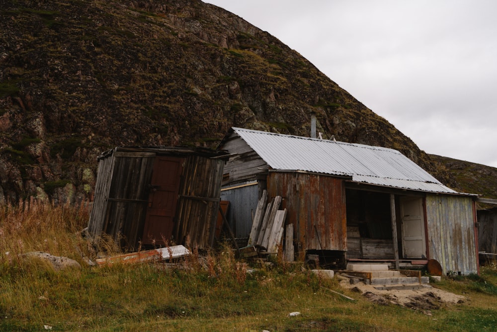 an old shack with a mountain in the background