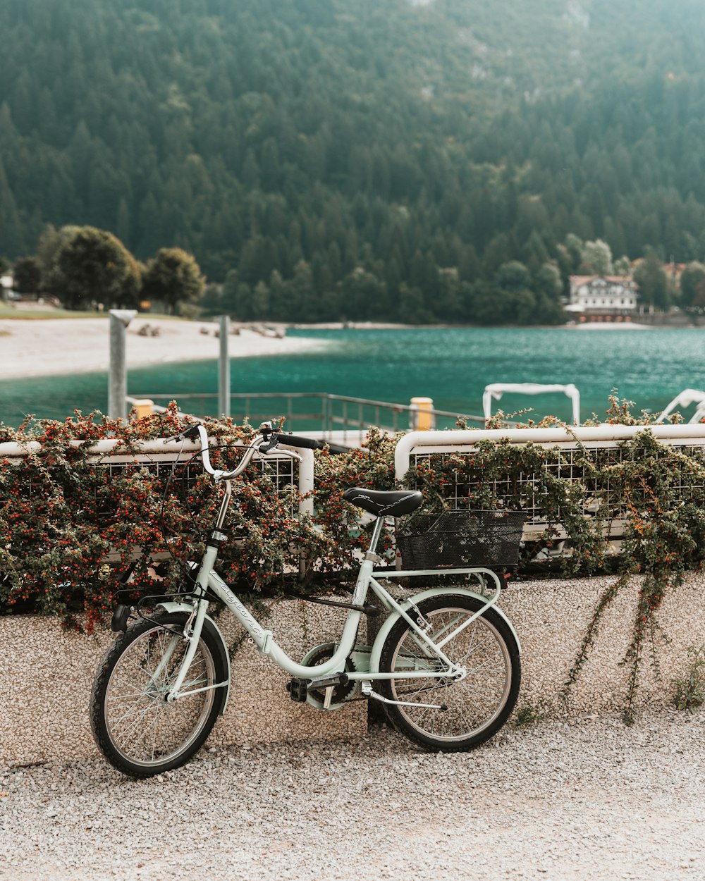 ein Fahrrad, das neben einem Zaun in der Nähe eines Gewässers geparkt ist