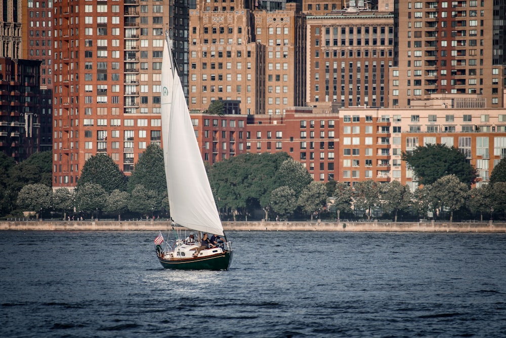 a sailboat in a body of water in front of a large city