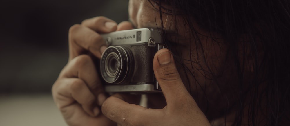 a woman holding a camera up to her face