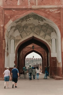 a group of people walking under an archway