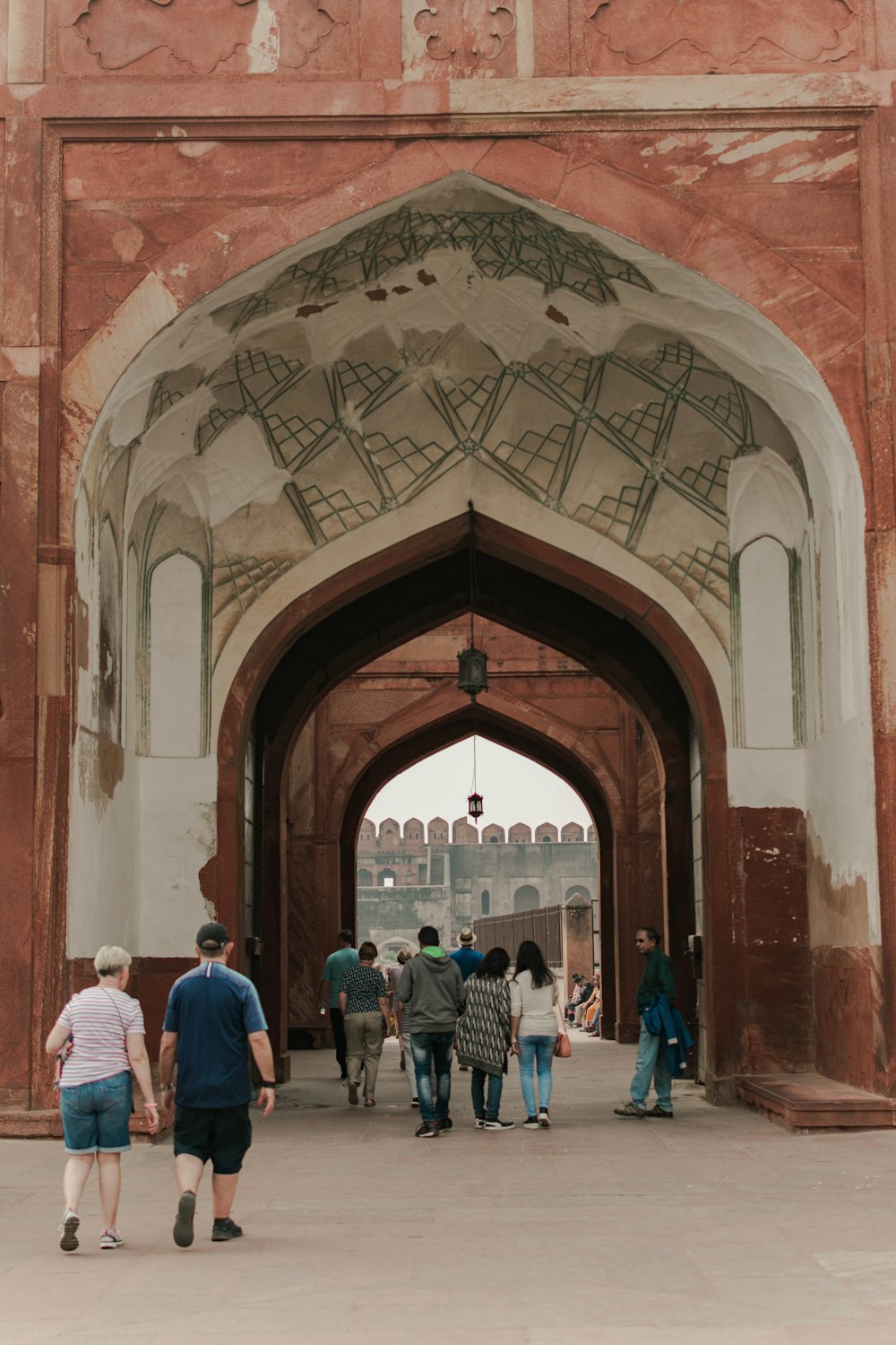 a group of people walking under an archway