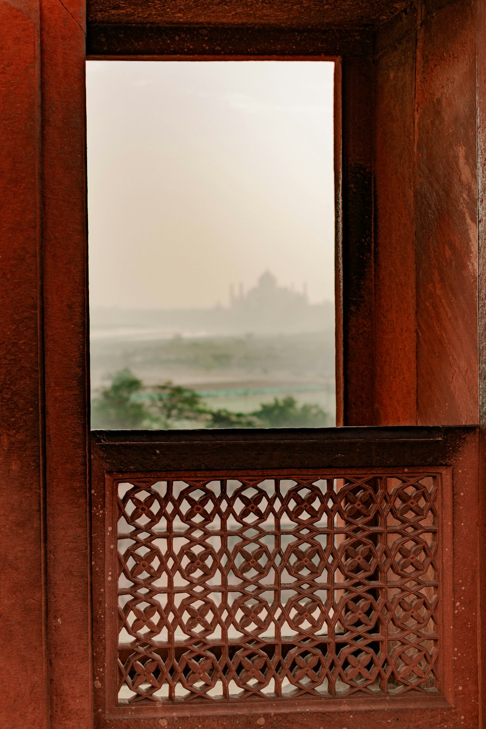 una ventana con vistas a un castillo en la distancia