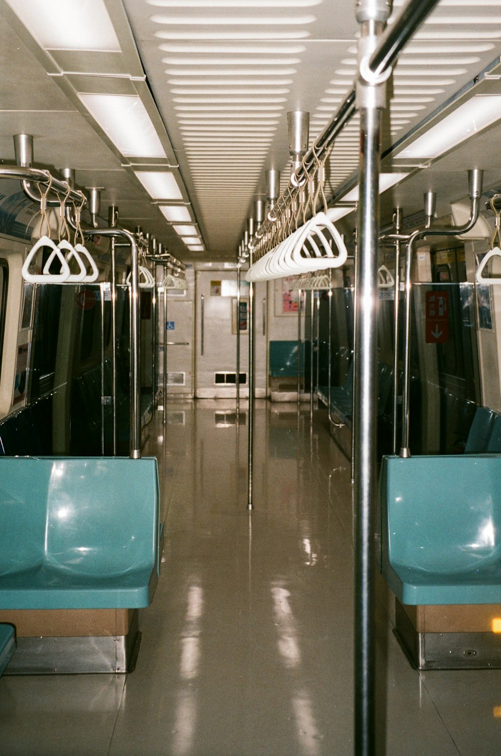 a subway car with blue seats and metal rails