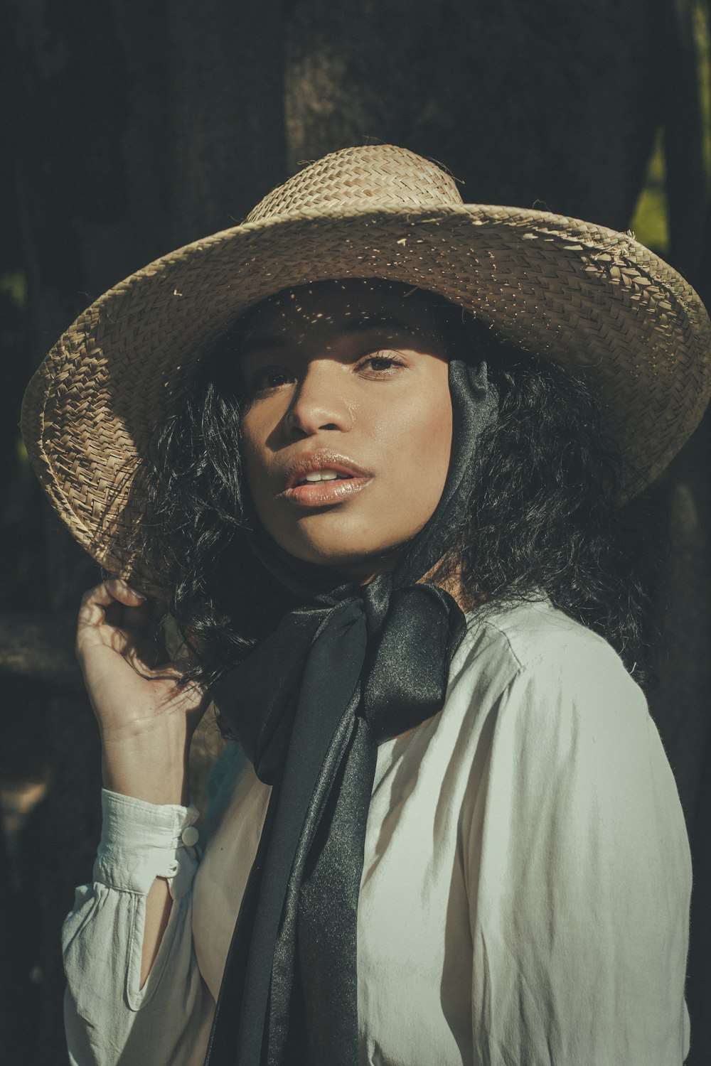 a woman wearing a hat and a black tie