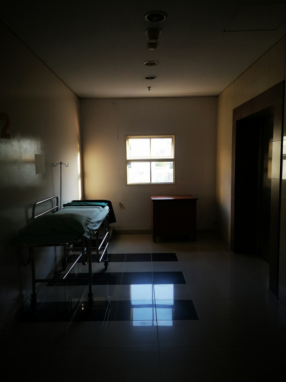 a dimly lit room with a hospital bed