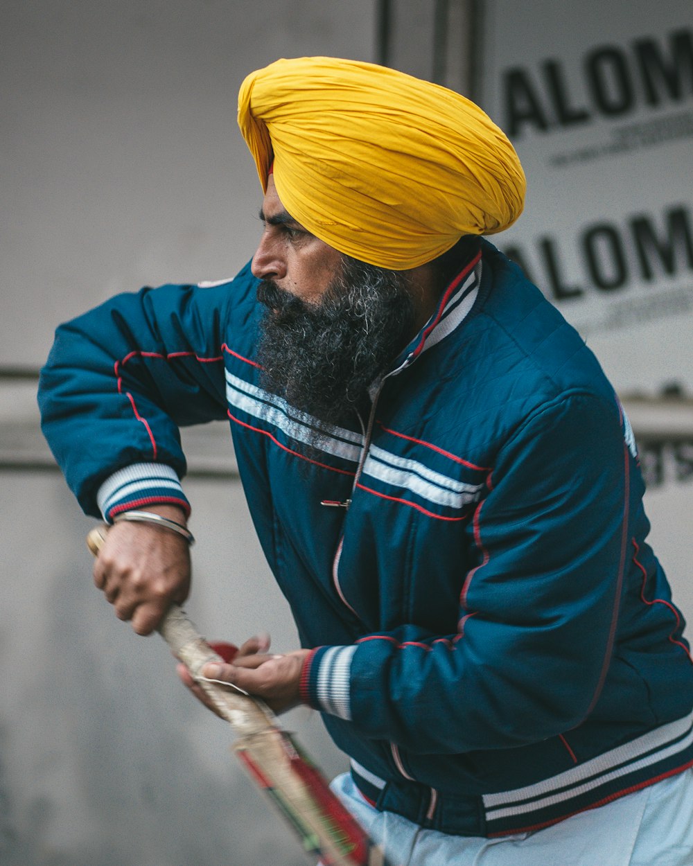 a man with a yellow turban holding a tennis racket