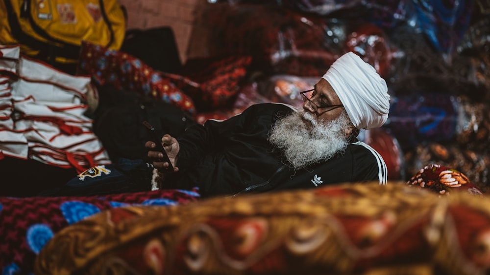 a man with a white turban sitting on a bed