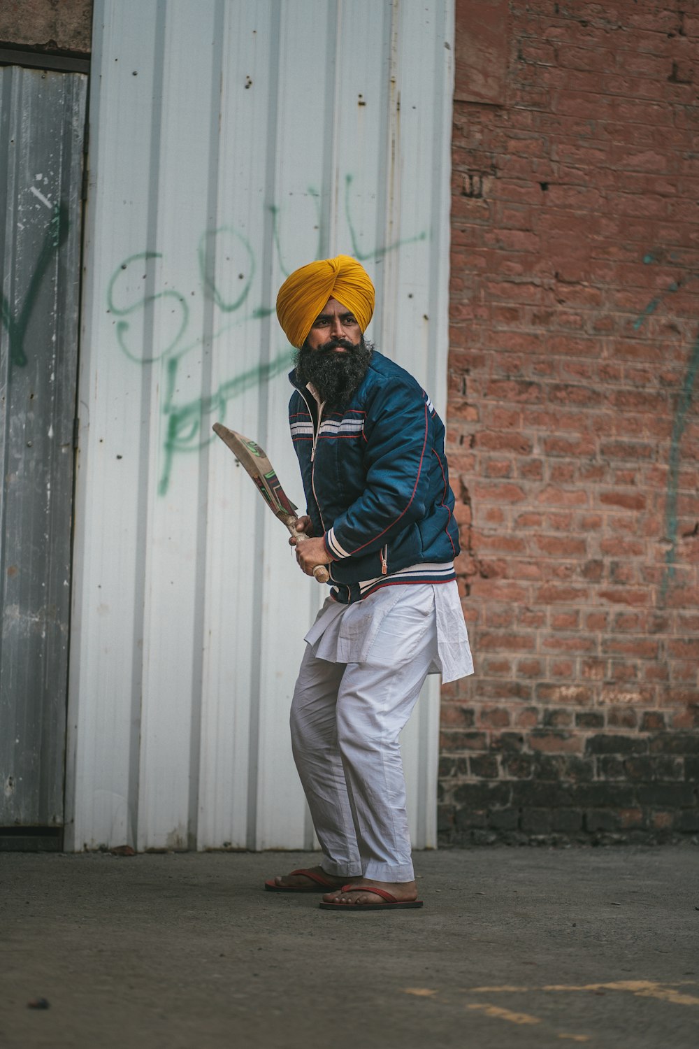 a man in a turban holding a tennis racquet