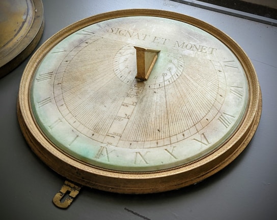 a clock with roman numerals on it sitting on a table