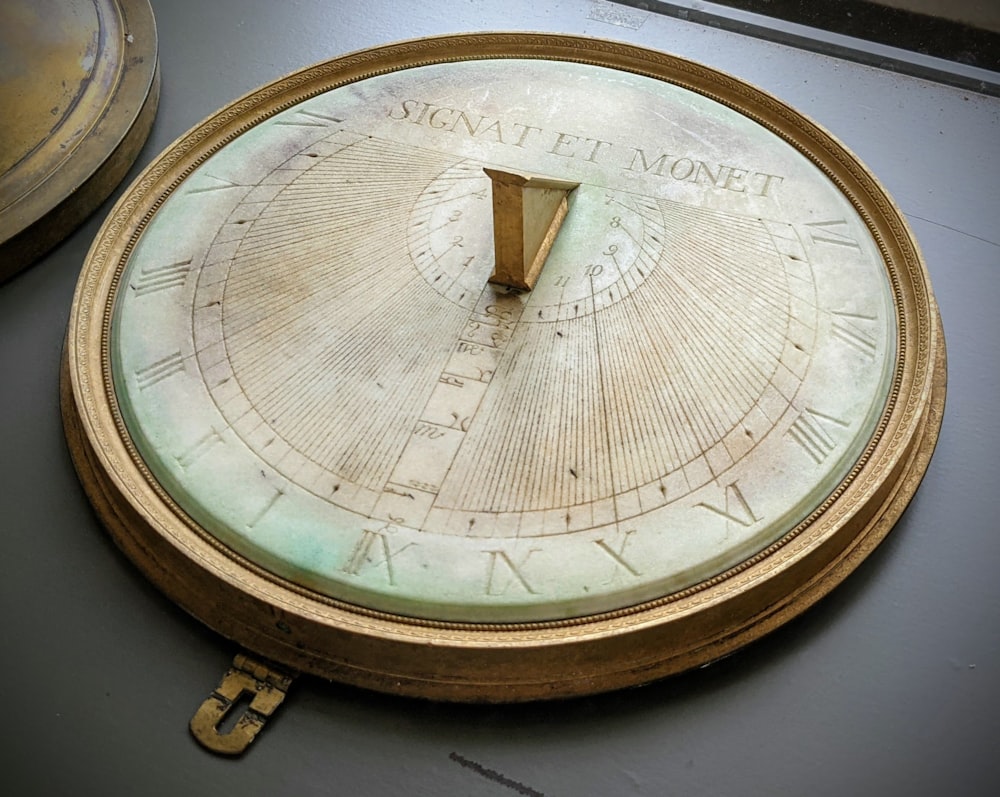 a clock with roman numerals on it sitting on a table