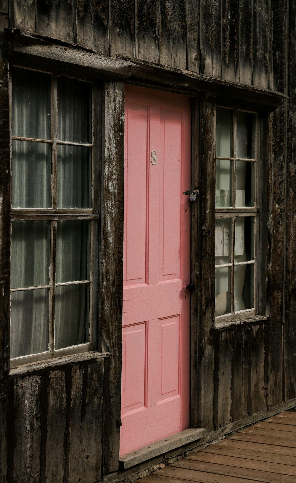 a pink door and window on a wooden building