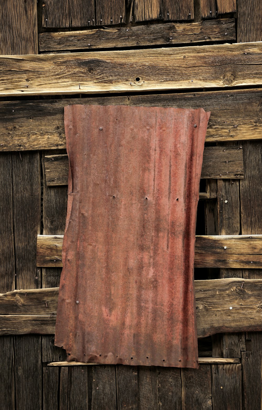 a piece of cloth hanging on a wooden wall