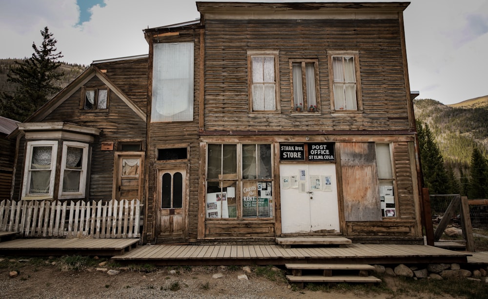 an old wooden building with a white picket fence