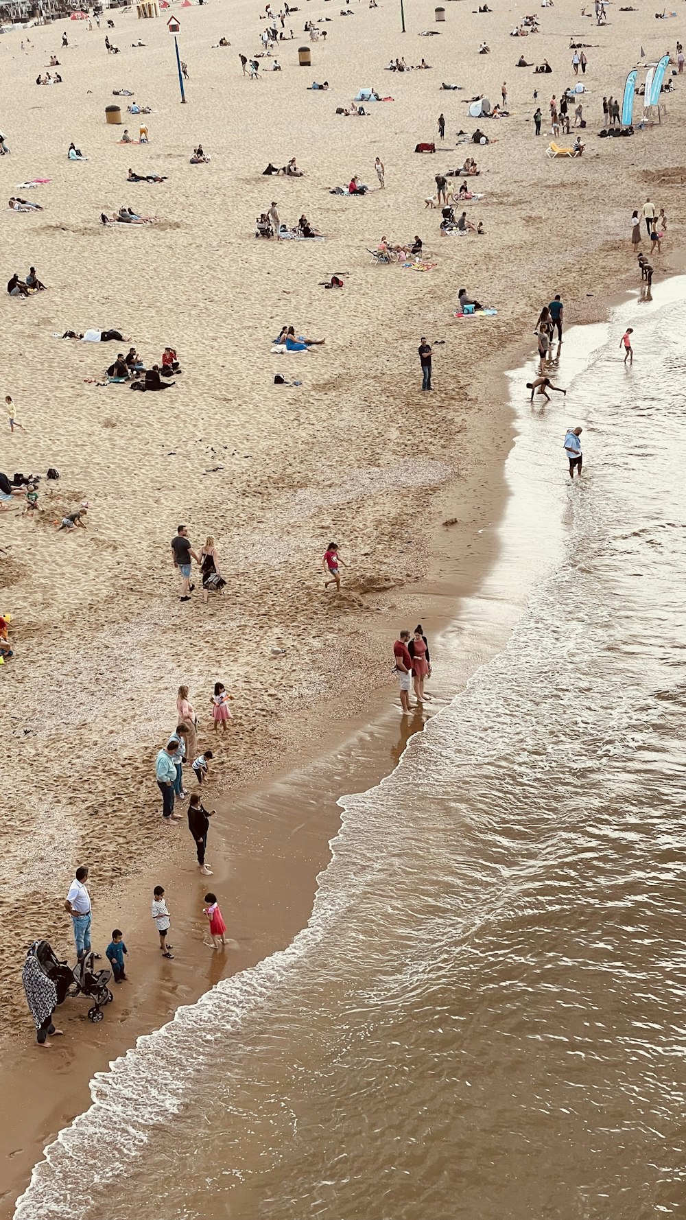 uma praia lotada com muitas pessoas nela