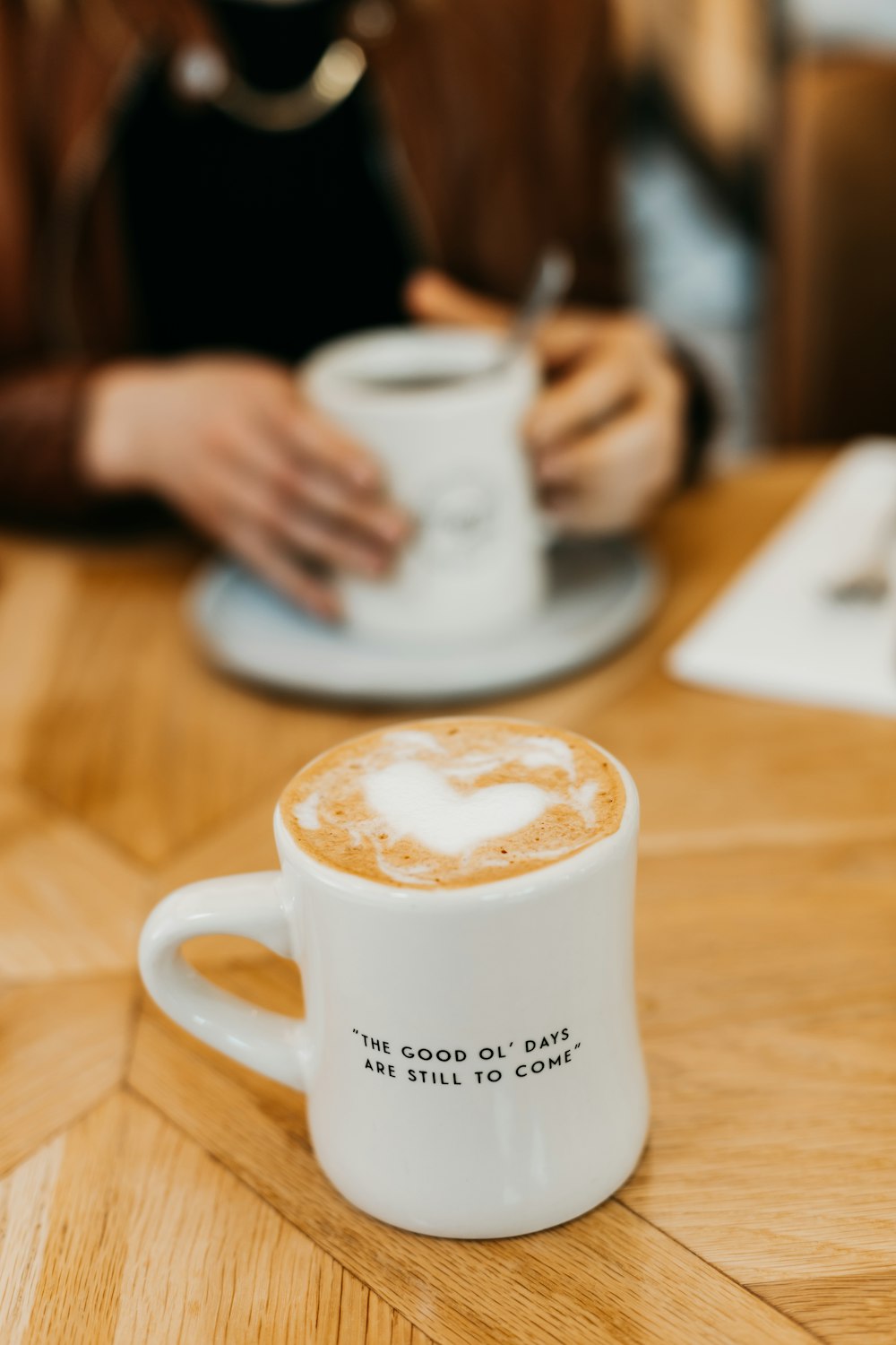 a person sitting at a table with a cup of coffee