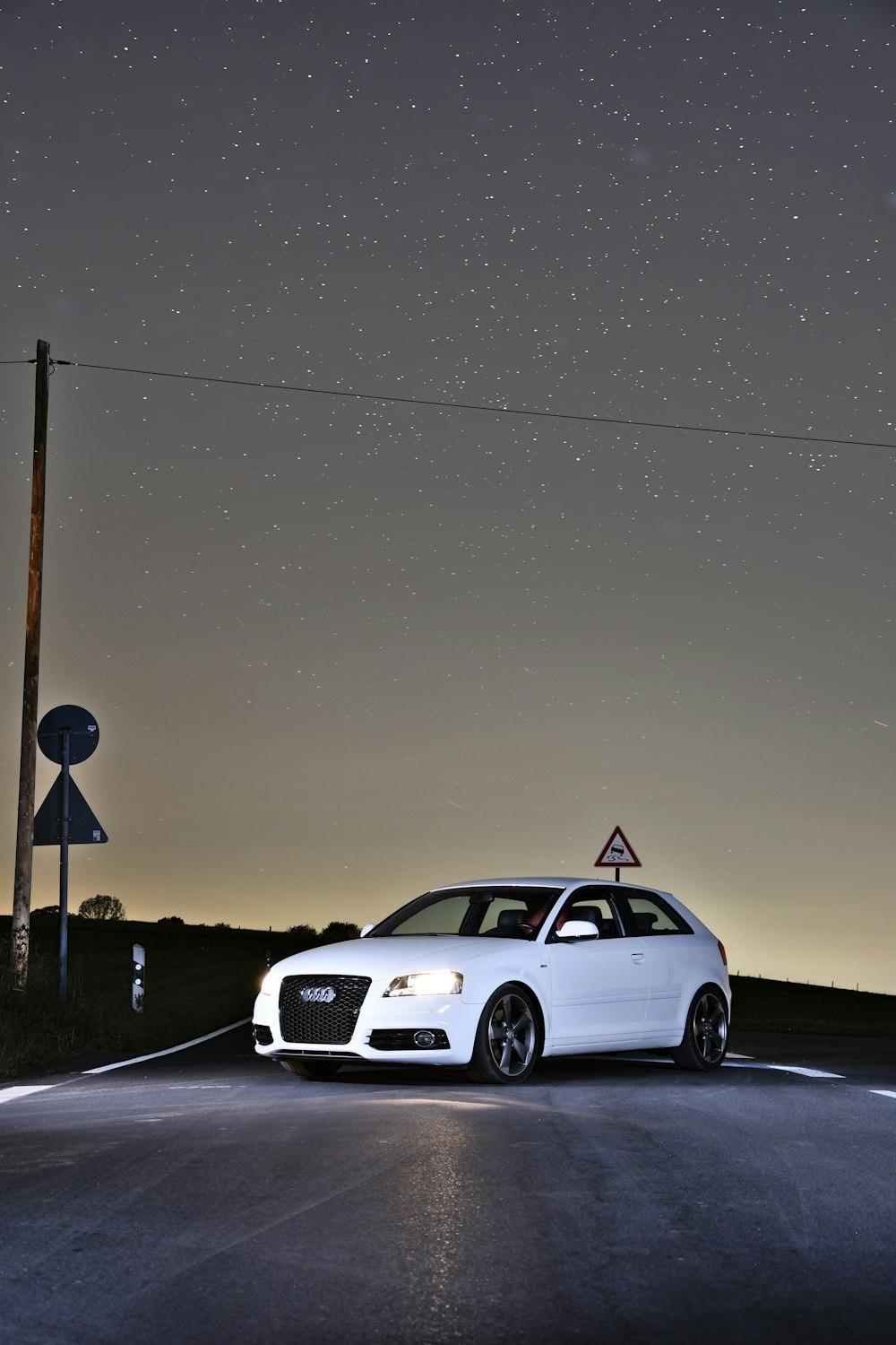 a white car parked on the side of a road