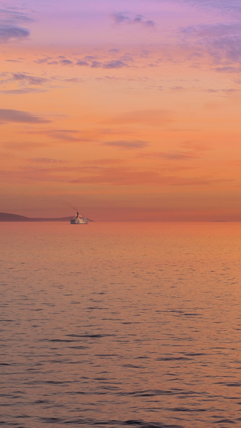 a large body of water with a boat in the distance