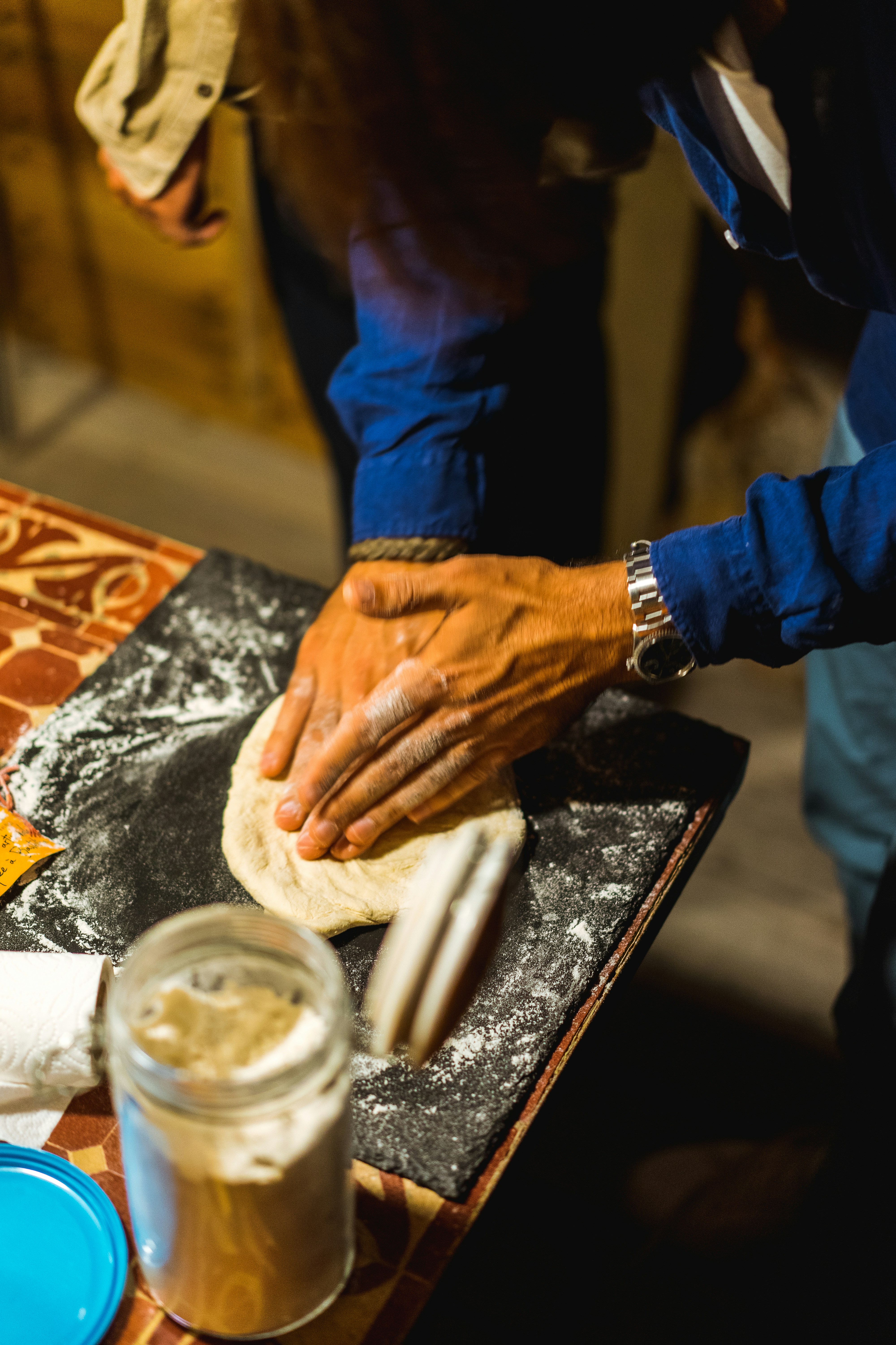 a person kneading a piece of bread on top of a table
