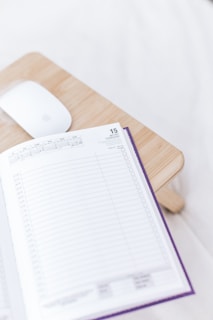 a wooden desk with a mouse and a book