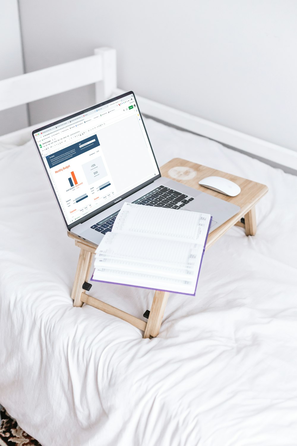 Ein Laptop sitzt auf einem Bett