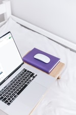 a laptop computer sitting on top of a bed