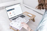 a person sitting on a bed with a laptop