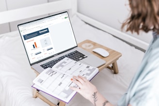 a person sitting on a bed with a laptop