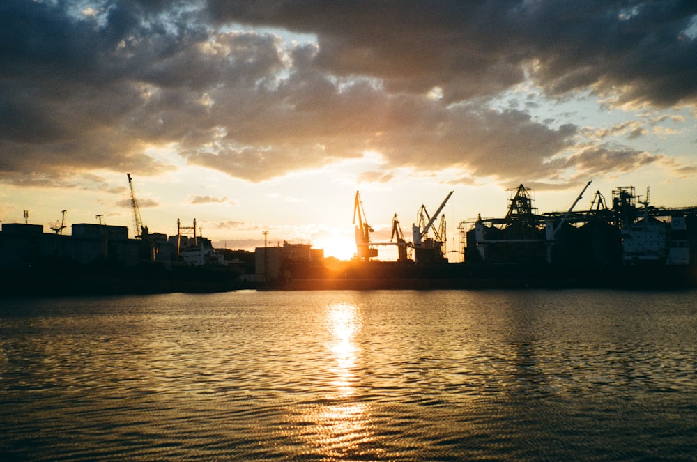 a large body of water with a sunset in the background