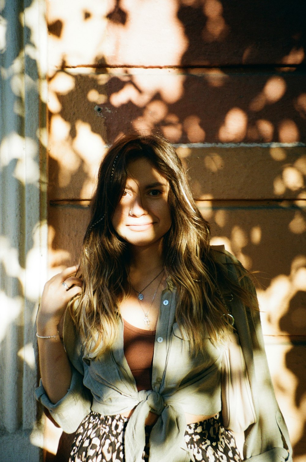 a woman standing in front of a wooden wall