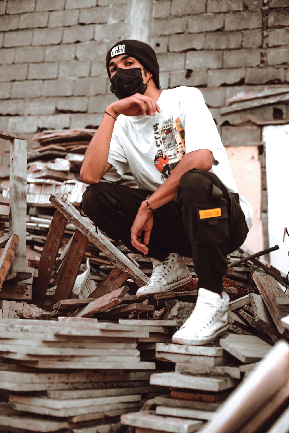 a man sitting on top of a pile of wood