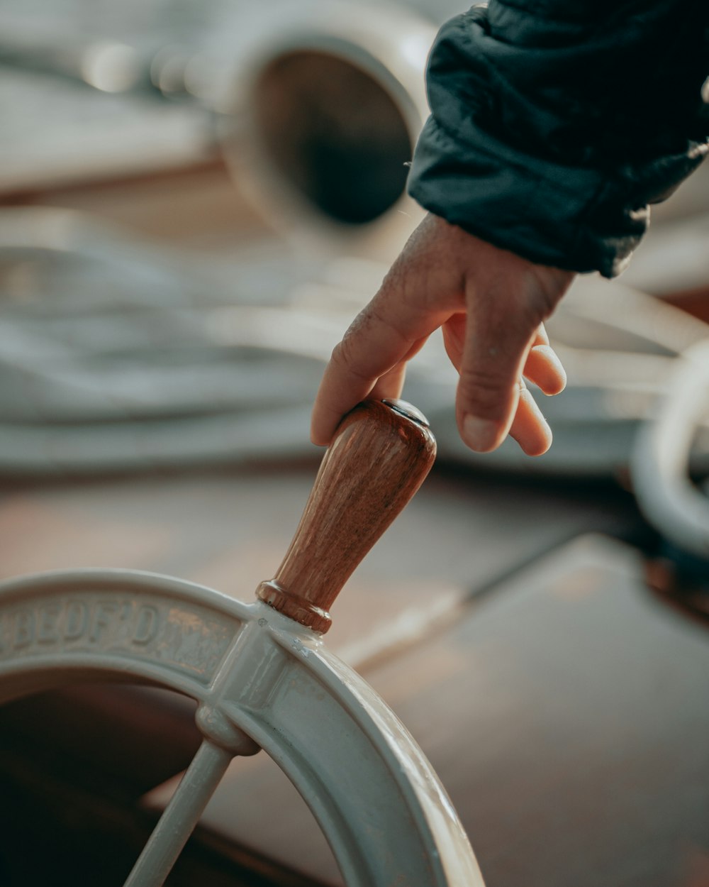 a person's hand on the steering wheel of a boat
