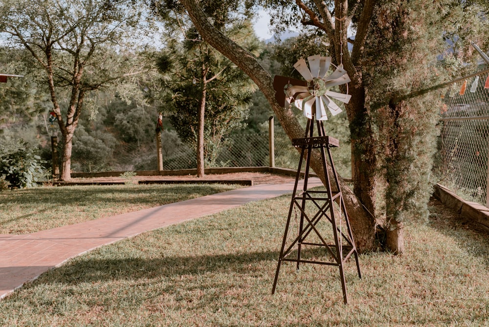 a windmill leaning against a tree in a park