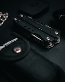 Compact Alpha Drive multi-tool laid out on a textured dark leather surface with subtle lighting.