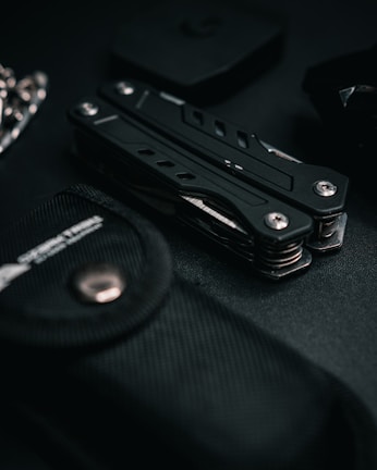 Compact Alpha Drive multi-tool laid out on a textured dark leather surface with subtle lighting.